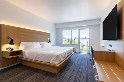 a hotel room with a bed and a flat screen tv at Hotel Mai Downtown Long Beach in Long Beach