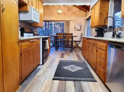 a kitchen with wooden cabinets and a rug on the floor at The Ponderosa in Running Springs