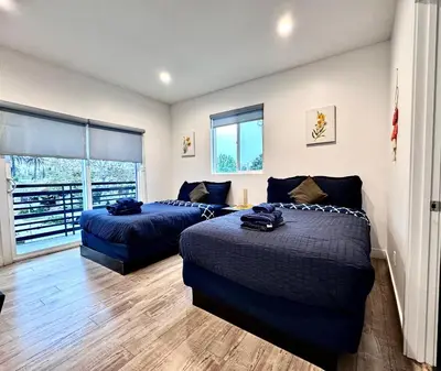 a bedroom with two beds and a balcony at 4BR/4BR modern house at Mid-city in Los Angeles