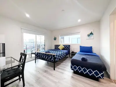 a bedroom with two beds and a glass table at Stylish 3 BR/3BR family house in Los Angeles