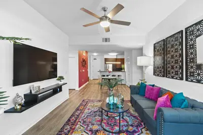 a living room with a blue couch and a tv at Fairfax District Chic City Oasis 2 BR Apt with Den 136 in Los Angeles