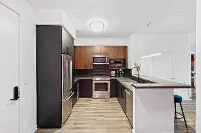 a kitchen with stainless steel appliances and wooden cabinets at Fairfax District Chic City Oasis 2 BR Apt with Den 136 in Los Angeles