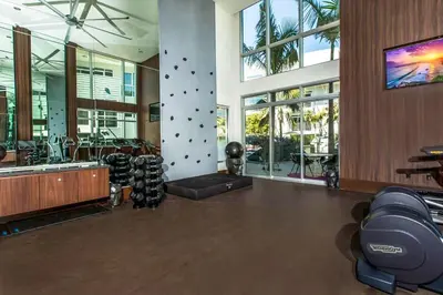 a gym with exercise equipment in a building with windows at Fairfax District Chic City Oasis 2 BR Apt with Den 136 in Los Angeles