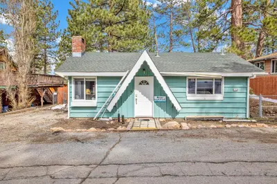 a blue house with a white door at Storyville Hot Tub- Arcade- Walk To Marina Cabin in Big Bear Lake