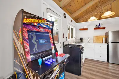 a kitchen with a video game on a refrigerator at Storyville Hot Tub- Arcade- Walk To Marina Cabin in Big Bear Lake