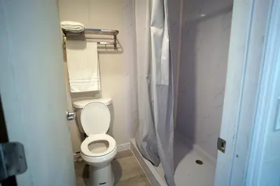 a bathroom with a toilet and a shower at Airport Stay Motel in Ontario
