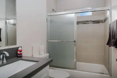 a bathroom with a shower and a toilet and a sink at Comfy 4BR home near Korea Town in Los Angeles