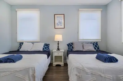 two beds in a room with blue pillows on them at Comfy 4BR home near Korea Town in Los Angeles