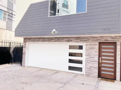 a garage with a white garage door on a house at Modern 3BR Home in Mid-City in Los Angeles
