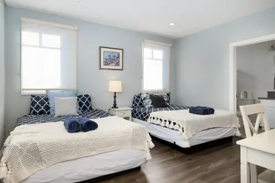 two beds in a room with blue walls at Stylish 4 BR house near Korea Town (Central LA) in Los Angeles