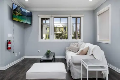 a living room with a white couch and a tv at Stylish 4 BR house near Korea Town (Central LA) in Los Angeles