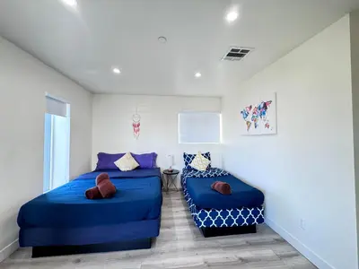 two beds in a room with blue pillows at Cozy Chamber 3 BR Hollywood Townhouse in Los Angeles
