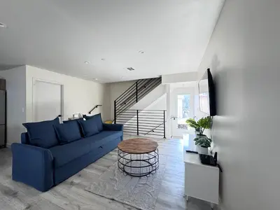 a living room with a blue couch and a table at Cozy Chamber 3 BR Hollywood Townhouse in Los Angeles