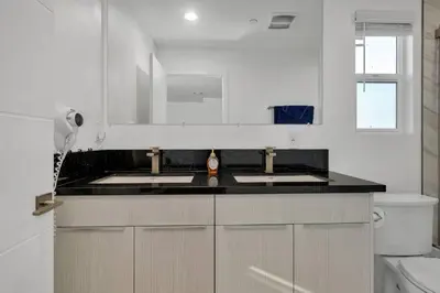 a white kitchen with two sinks and a toilet at Wonderful 3 Bedroom Home Perfect for Getaway in Los Angeles