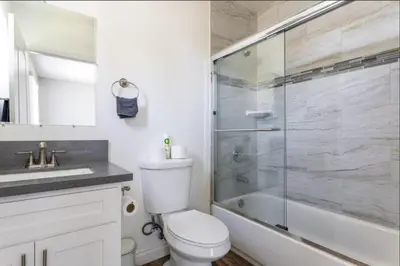 a bathroom with a toilet and a glass shower at 5 BR Home Near USC - Perfect Location in Los Angeles