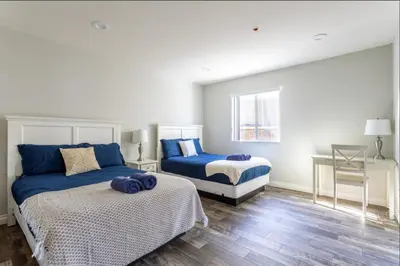 a bedroom with two beds with blue pillows on them at 5 BR Home Near USC - Perfect Location in Los Angeles