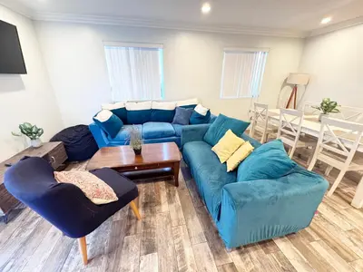 a living room with a blue couch and a table at 5 BR Home Near USC - Perfect Location in Los Angeles