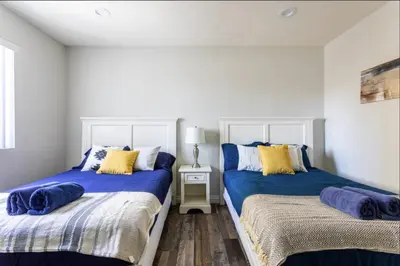 two beds in a bedroom with blue and yellow pillows at Cheerful 5BR house with parking near USC in Los Angeles