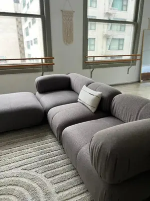 a couch sitting in a living room with a rug at Historic Downtown LA Loft - Urban Charm in Los Angeles