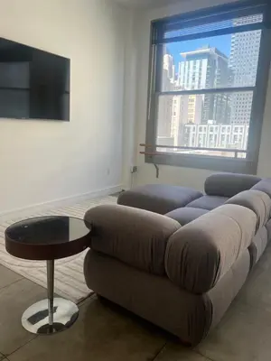 a living room with a couch and a table and a window at Historic Downtown LA Loft - Urban Charm in Los Angeles