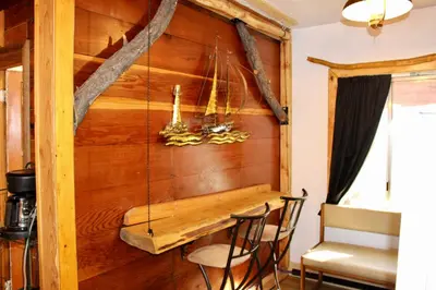 a room with a wooden wall with a table and chairs at Boulder Bay Cottages in Big Bear Lake