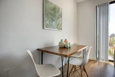 a dining room with a wooden table and white chairs at Culver City 1br w rooftop lounge access to 405 LAX-1124 in Los Angeles