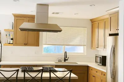 a kitchen with wooden cabinets and a stove top oven at Bright Corner Home Retreat Near SoFi in Los Angeles