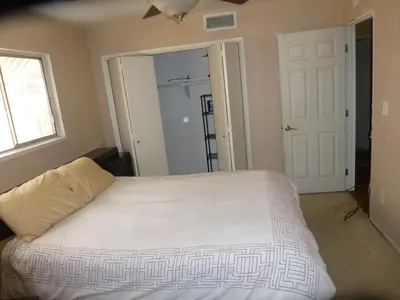 a bedroom with a white bed and a window at Nice Northridge 4-2-2 home near CSUN and Pierce College in Northridge