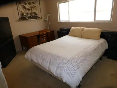 a bedroom with a large white bed with a window at Nice Northridge 4-2-2 home near CSUN and Pierce College in Northridge