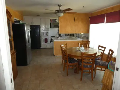 a kitchen with a table and chairs and a black refrigerator at Nice Northridge 4-2-2 home near CSUN and Pierce College in Northridge
