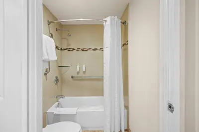 a white bathroom with a tub and a toilet at Howard Johnson by Wyndham Pasadena in Pasadena