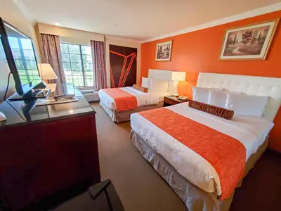 a hotel room with two beds and a flat screen tv at Howard Johnson by Wyndham Pasadena in Pasadena