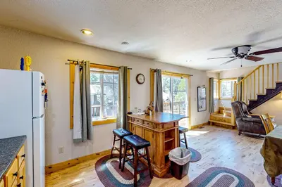 a kitchen with a refrigerator and a table in a room at Heliotrope Hideaway in Lake Arrowhead