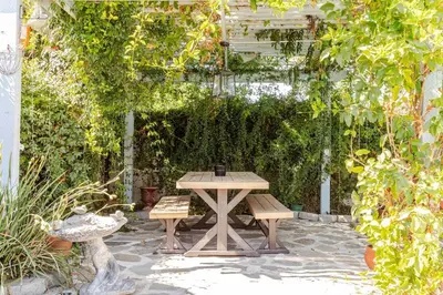 a picnic table and two benches in a garden at Newly Furnished Pool House in Los Angeles