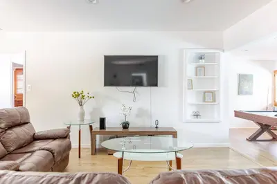 a living room with a couch and a table at Newly Furnished Pool House in Los Angeles