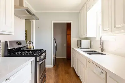 a kitchen with white cabinets and a stove top oven at Newly Furnished Pool House in Los Angeles