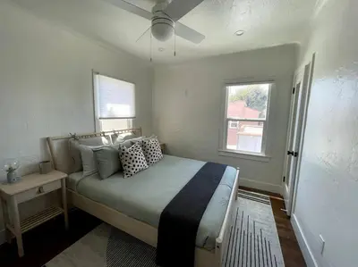 a bedroom with a bed and a window at Huge Updated Spanish Apt - Steps to Beach & Bay! in Long Beach
