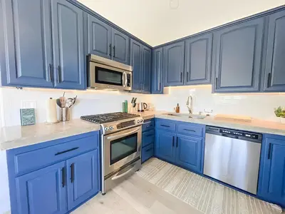 a blue kitchen with stainless steel appliances and blue cabinets at NEW & Luxurious House, hot tub & amazing views in Lake Arrowhead