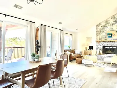 a living room with a table and chairs and a fireplace at NEW & Luxurious House, hot tub & amazing views in Lake Arrowhead