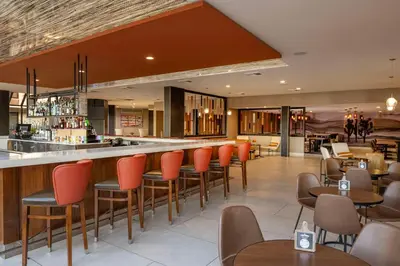 a restaurant with orange chairs and a bar at DoubleTree by Hilton San Bernardino in San Bernardino