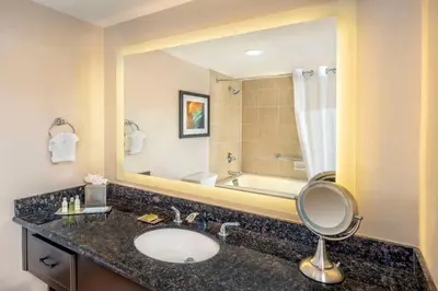 a bathroom with a sink and a large mirror at DoubleTree by Hilton San Bernardino in San Bernardino