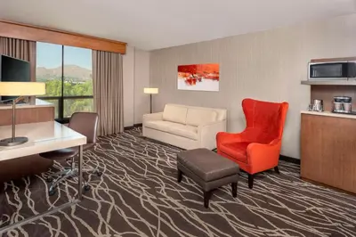 a hotel room with a couch and a chair and a desk at DoubleTree by Hilton San Bernardino in San Bernardino