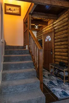 a staircase in a log cabin with a door at Pine Mountain Club Family Vacation House in Pine Mountain Club