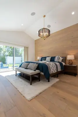 a bedroom with a large bed and a chandelier at Universal Studio Stellar Home with pool and jacuzzi in Los Angeles