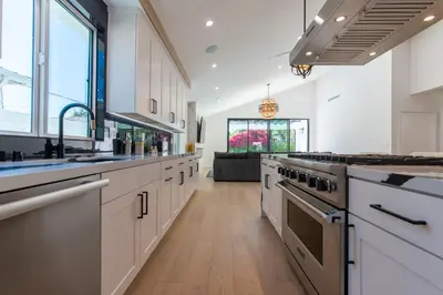 a large kitchen with white cabinets and stainless steel appliances at Universal Studio Stellar Home with pool and jacuzzi in Los Angeles