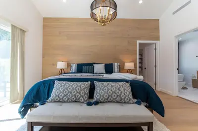 a bedroom with a large bed with a blue comforter at Universal Studio Stellar Home with pool and jacuzzi in Los Angeles