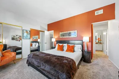 a bedroom with a large bed with orange walls at Beverly Hills 2 bed 2 bath Penthouse with Den and Parking 414 in Los Angeles