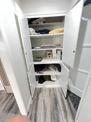 a walk in closet with white cabinets at Little Bettys Cottage in Torrance
