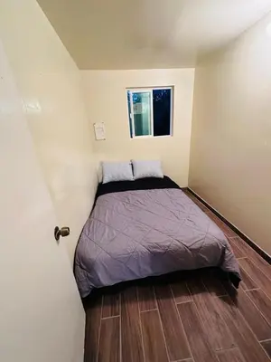 a small bedroom with a bed in the corner at Zen Home in Santa Ana