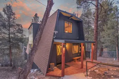 a black tiny house in the woods at Stunning Cabin with Private Deck in Big Bear City
